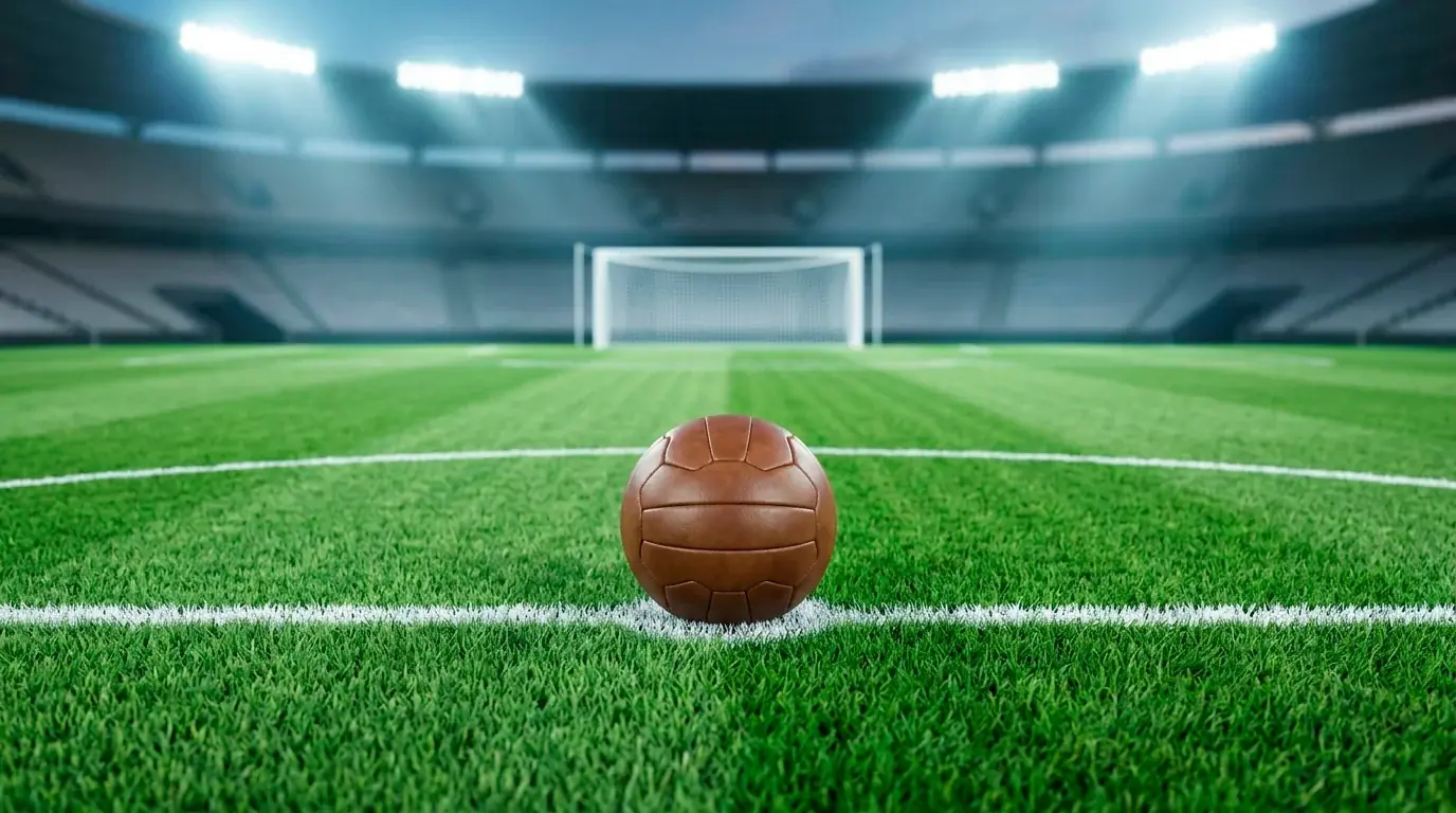Nahaufnahme eines Spielballs auf dem Anstoßpunkt eines leeren, hell beleuchteten Fußballrasens vor dem Anpfiff bei der WM 2026